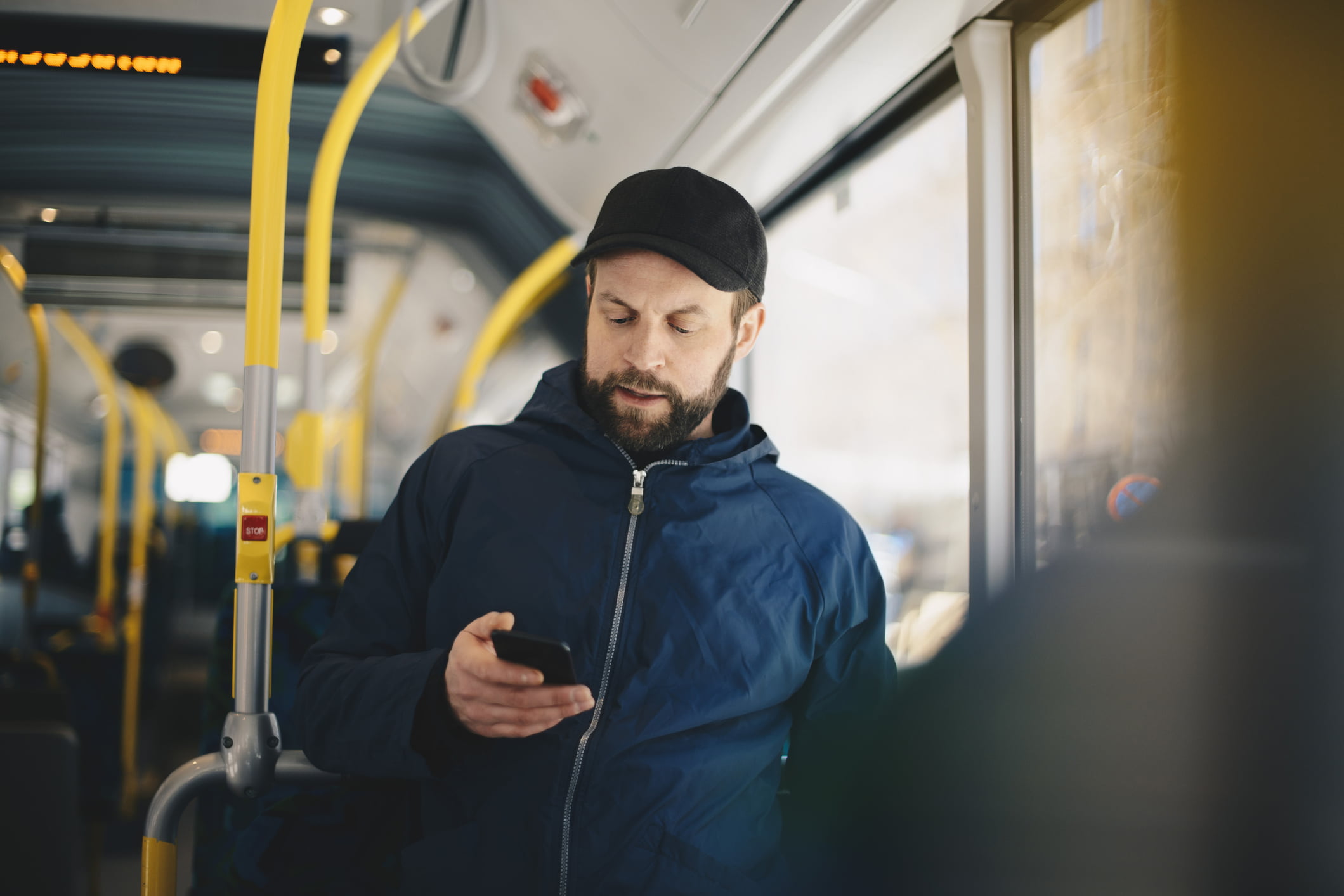Man står med mobilen på bussen