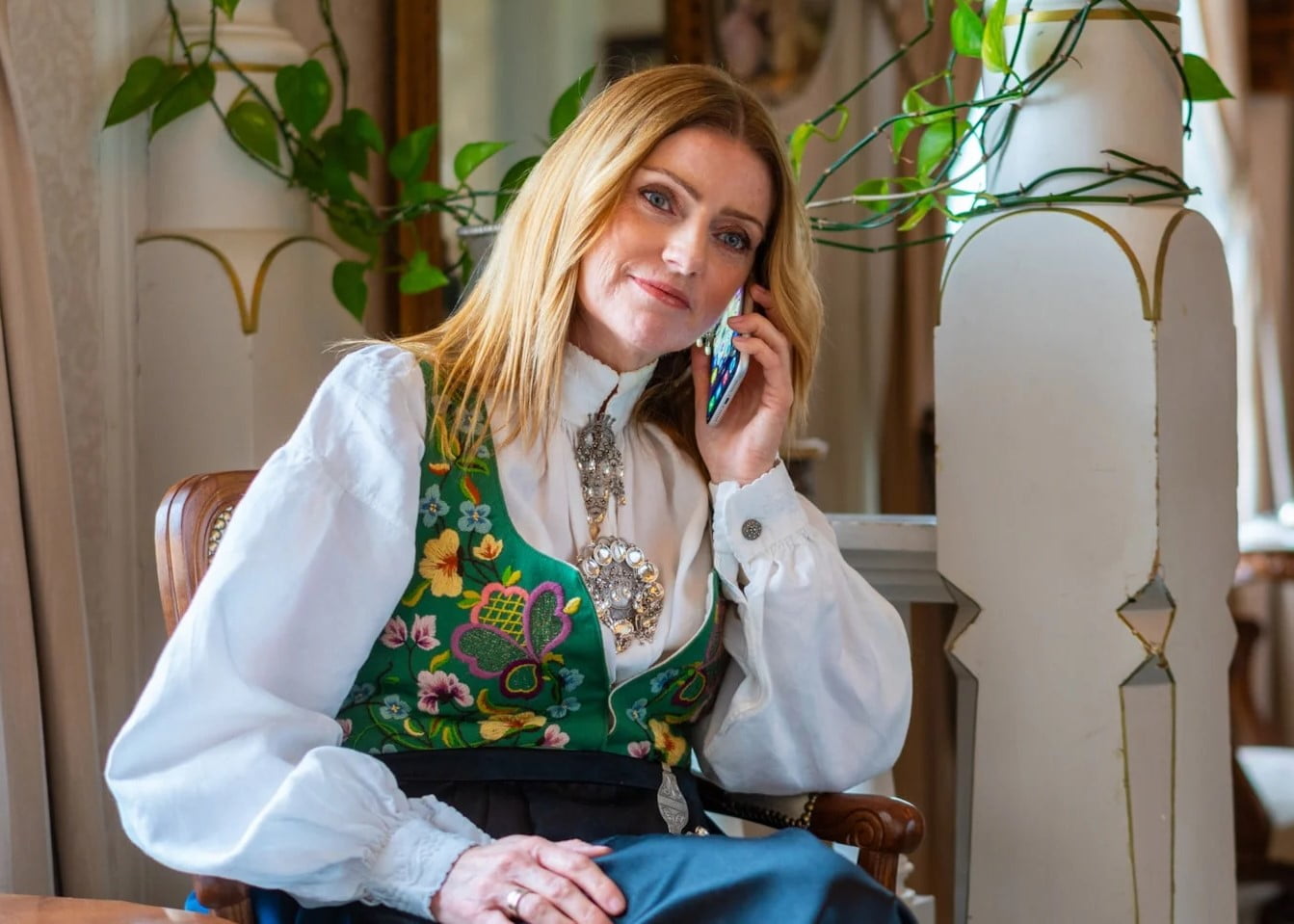 Dame i flott bunad snakker i telefonen