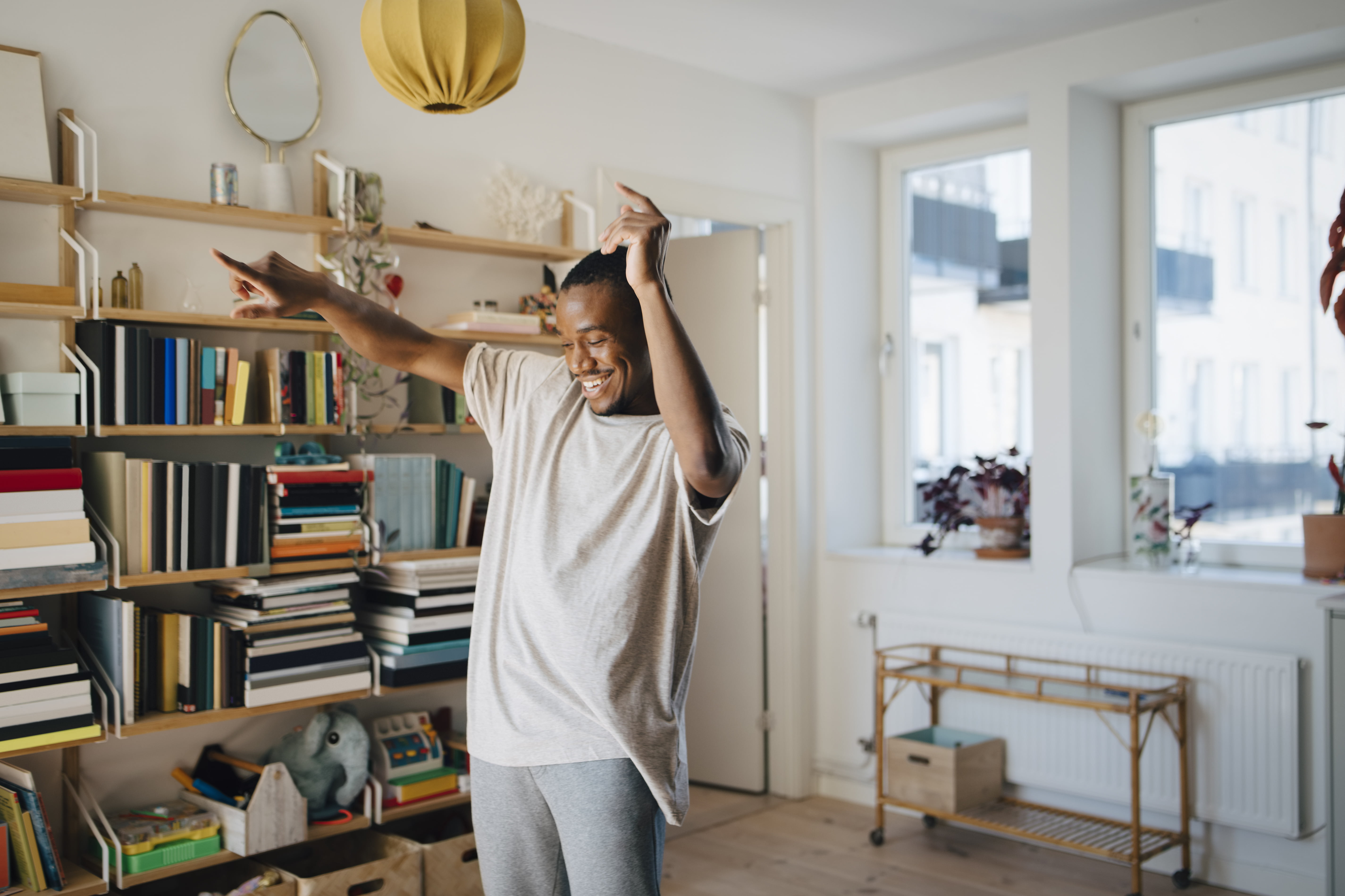 Glad mann som danser i stuen - råd for å komme inn på boligmarkedet