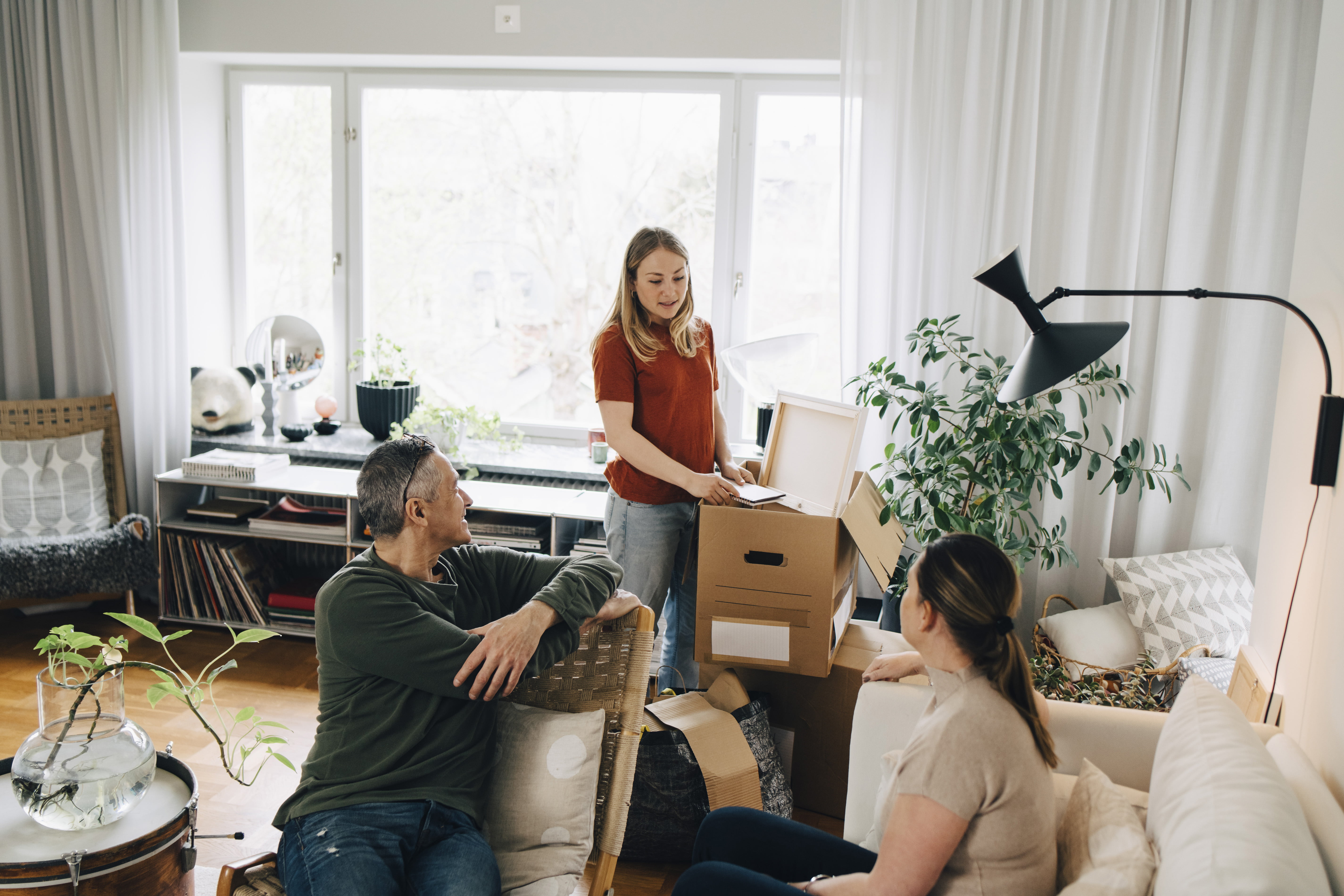jente med familie som står med flytteesker