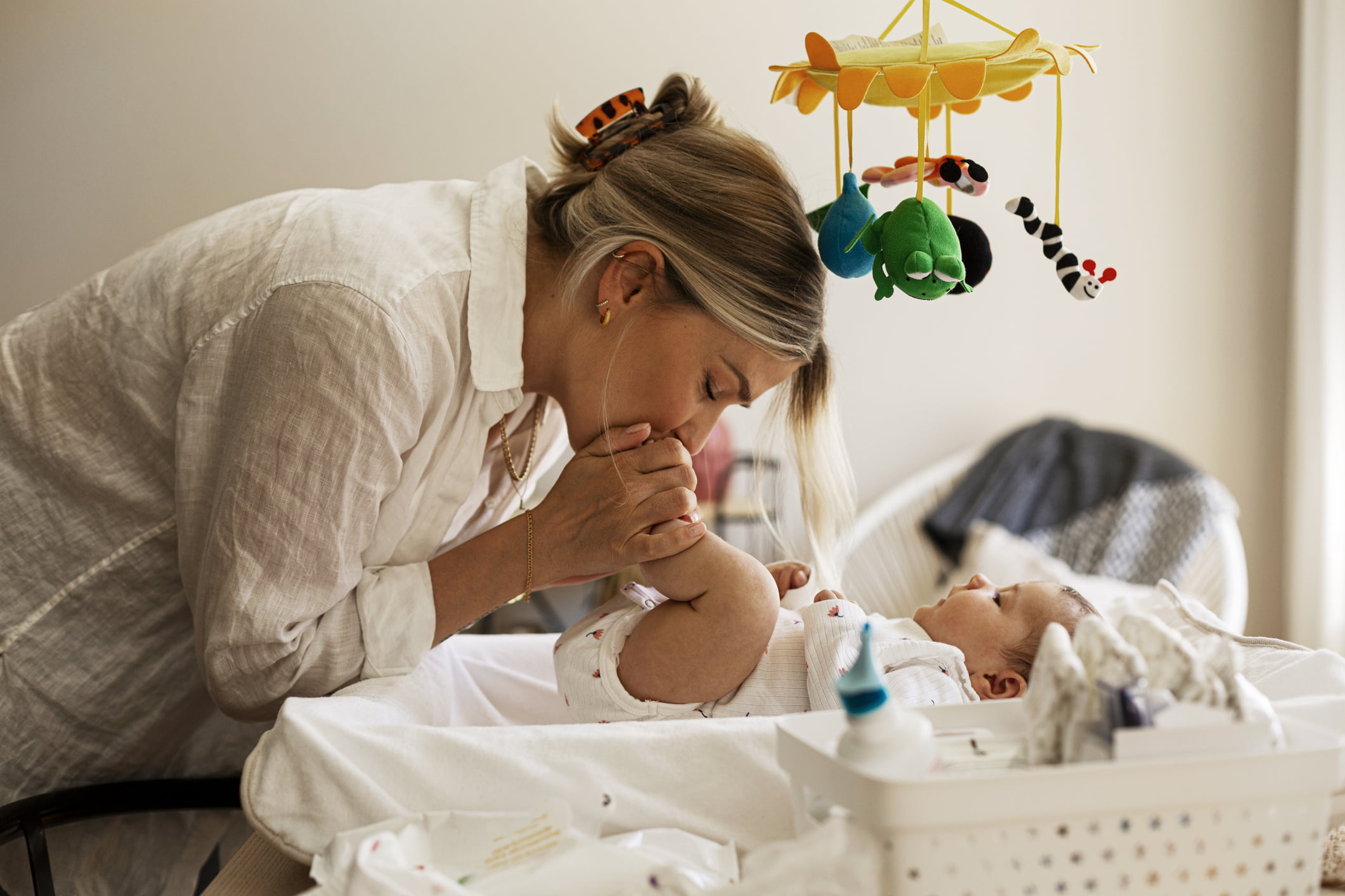 Mor som leker med baby på stellebord