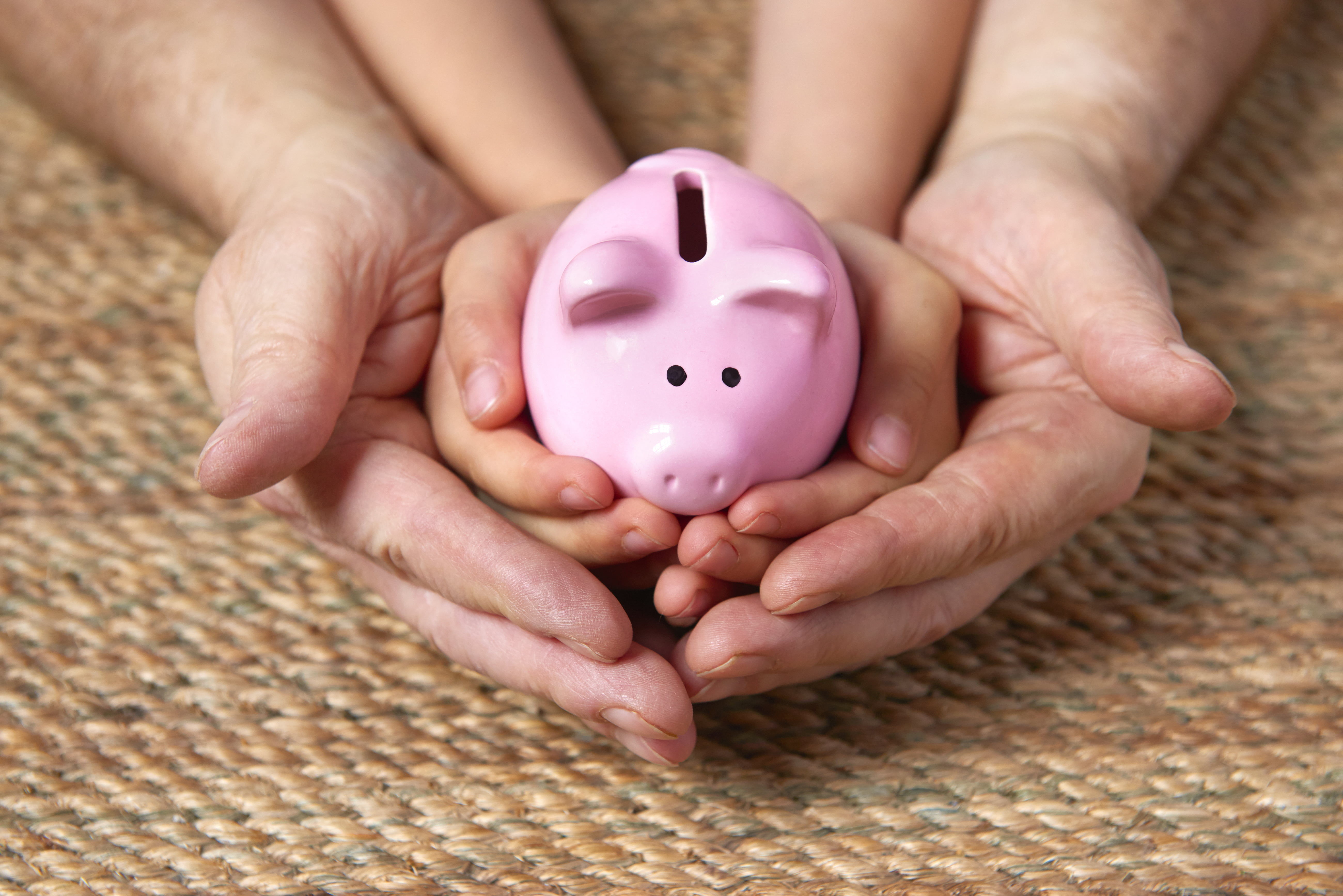 father and son cradling piggy bank of future savings