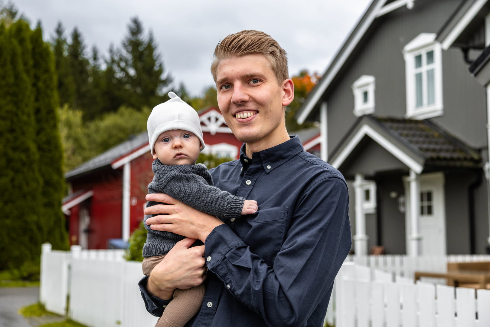 En ung mann holder en liten baby i armene