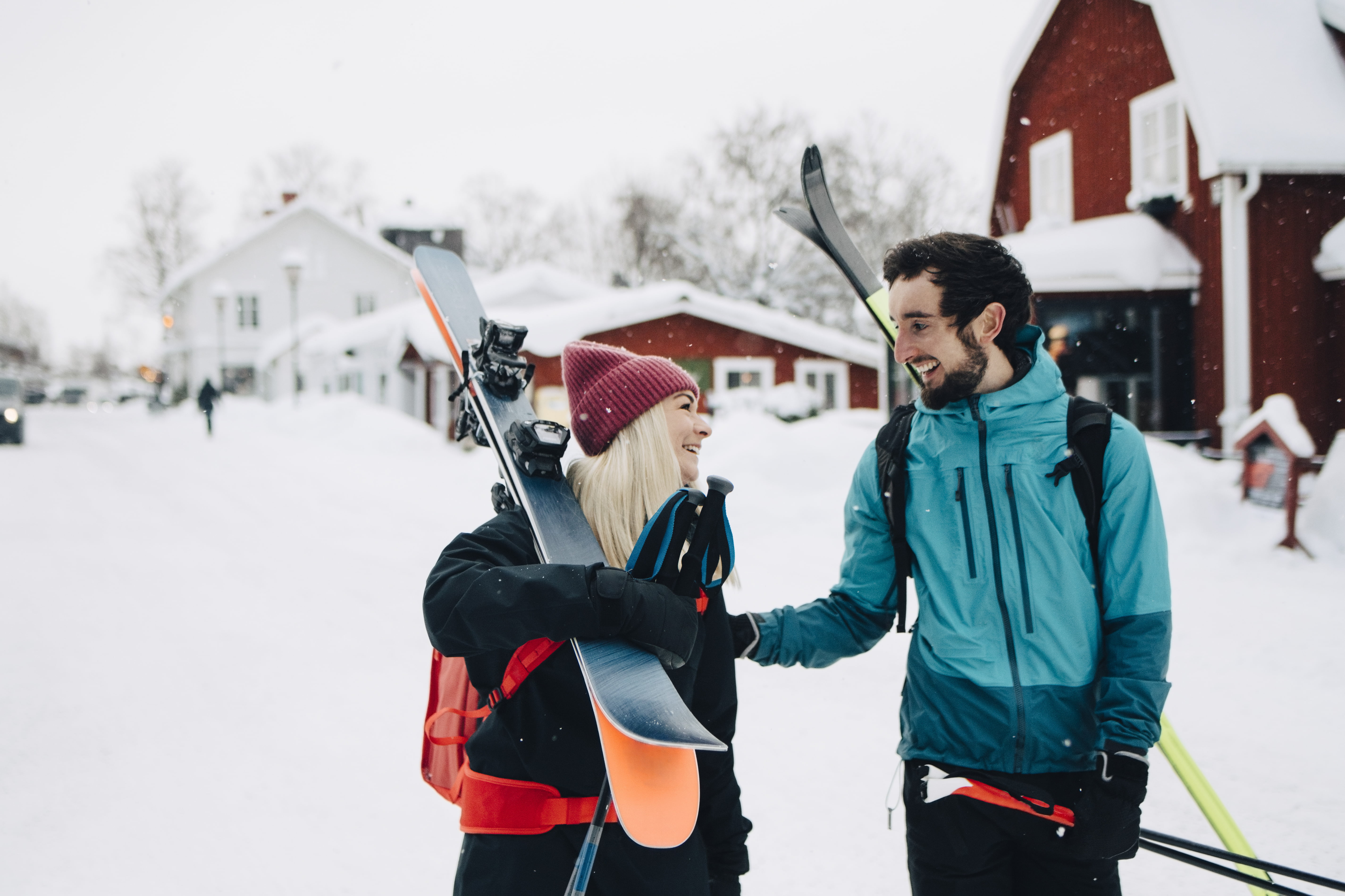 Mann og dame med ski på ryggen